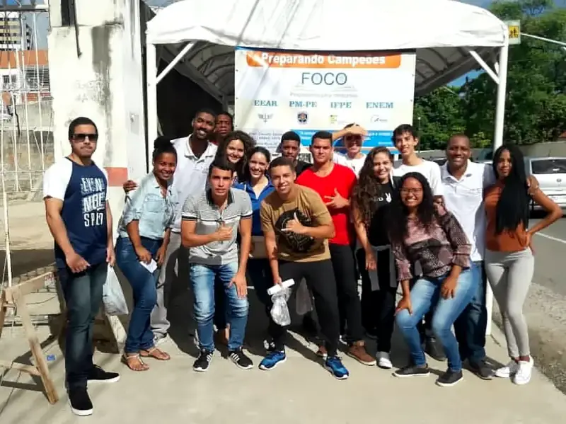 Turma em frente à tenda do Foco com a faixa Preparando Campeões